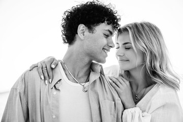 Smiling beautiful woman and her handsome boyfriend. Couple in casual summer clothes. Happy cheerful family. Female and man having fun. They posing in the street in sunny day. Black and white