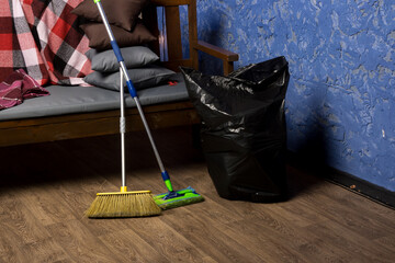 A practical cleaning setup with tools like a broom and mop on the floor, ready for household chores. Great for stock images on everyday home routines.