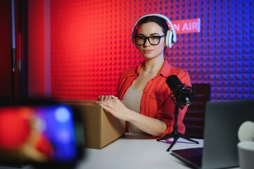 Female beauty blogger with fashionable clothes recording video in studio