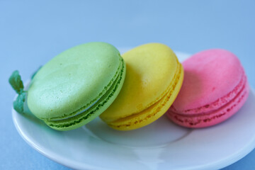 Colorful macaroons on a white plate, close up.