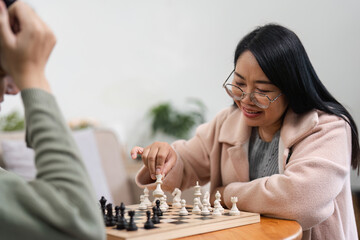 Mother and Son Enjoy Quality Time Playing Board Games Together in a Cozy Home Setting