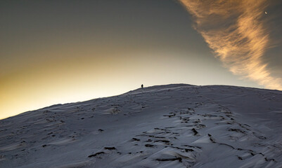 A wanderer at the mountain at dawn in winter