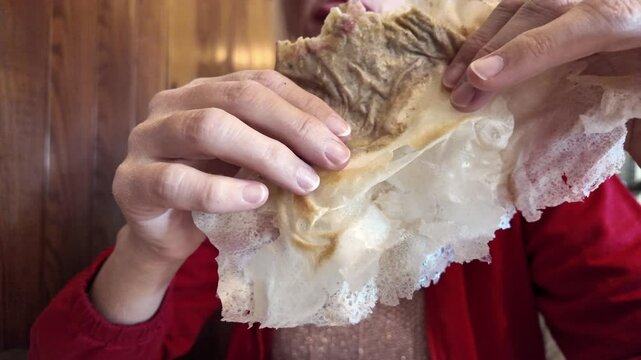 enjoying a Borlengo, delicious meal originating from the Emilia-Romagna region of Italy. Packed with meat and cheese, this traditional treat is beloved by locals in both Modena and Bologna.SLOW MOTION