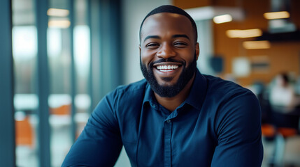 Obraz premium Smiling Black businessman dressed in a blue shirt working in a modern office during the day