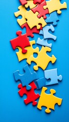 Obraz premium Colorful Jigsaw Puzzle Pieces Scattered on Blue Background, Concept of Problem Solving and Teamwork