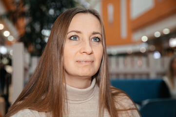 Woman with long hair in indoor setting with soft lighting and background blur