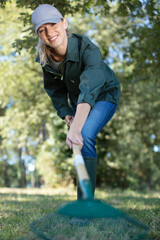 woman holding rake in backyard in autumn