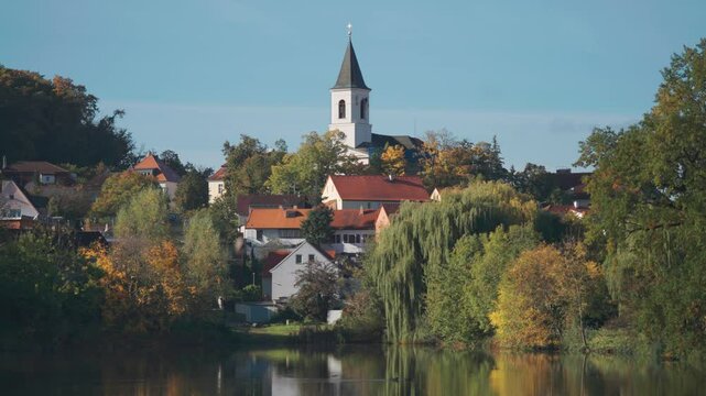 St. Sebastian's and Fabian's Church in Prague stands above the pond surrounded by greenery and small tidy houses.