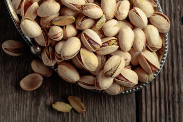 Salted pistachios on an old wooden table.