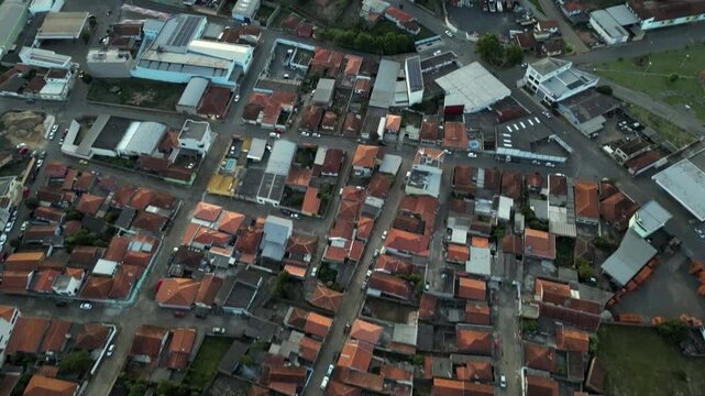 tilt up aerial view of houses in the city of Bueno Brandao and the green mountains surrounding the city - Serra da Mantiqueira, South of MInas Gerais- Brazil