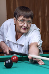 Grandma is relaxing in a billiard club.