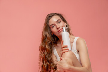 close up studio beauty shoot on pink background long-haired girl sitting posing in underwear with a...