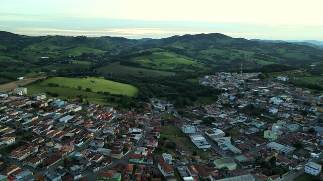 aerial view of a small city surrounded by a range of Mountains in the State of Minas Gerais, Bueno Brandao - Brazil