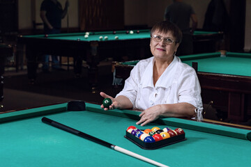 Grandma is relaxing in a billiard club.