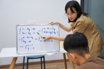 Young Asian female teacher works as a home tutor for a high school student
