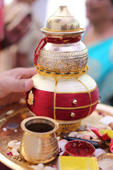 Traditional Indian kalash adorned with red and gold decorations, symbolizing prosperity and purity in sacred rituals.