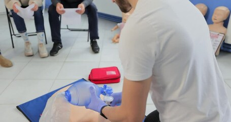 Man using CPR technique on dummy in first aid class. Oxigen mask on medical doll.