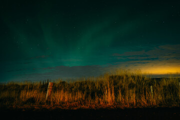 Small aurora borealis above Icelanding farm on the night sky