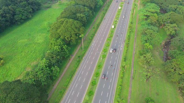 straight 6 lane road with trees on both side