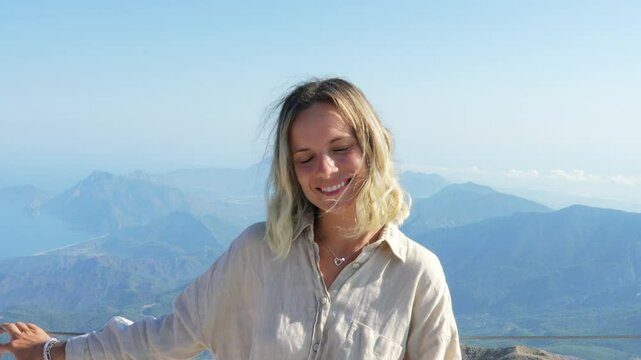 The woman is smiling at the mountains.