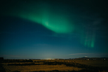Aurora borealis above Icelanding farm on the night sky