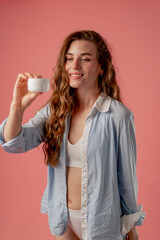 close up studio beauty shoot on pink background long-haired girl posing in underwear and blue shirt...