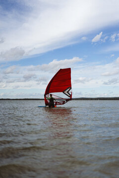 Man windsurfing in sea against blue sky