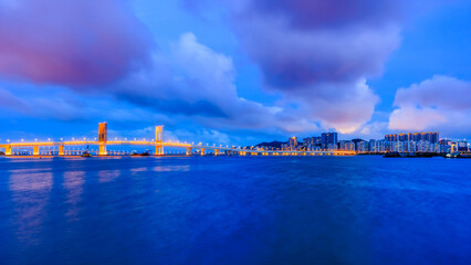 Beautiful coastline and bridge with residential area buildings scenery at night in Macau. Panoramic view.