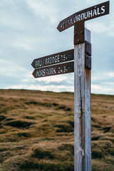 Direction sign, Crossroad signpost. Wooden signboard. Hiking trail signpost, Guiding sign. Iceland