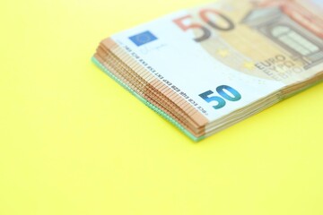 Big amount of one hundred and fifty euro money bills on yellow background