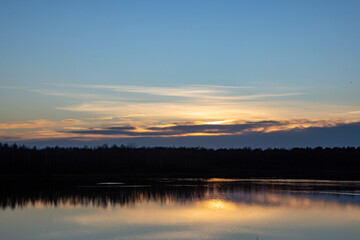 A tranquil and serene sunset reflection shimmering on a calm lake beneath a stunningly colorful sky