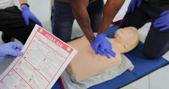 CPR First Aid training concept. Back view of woman holding first aid instruction during cpr training class.