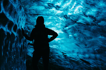 Person figure standing on an blue, ice cave background in Iceland