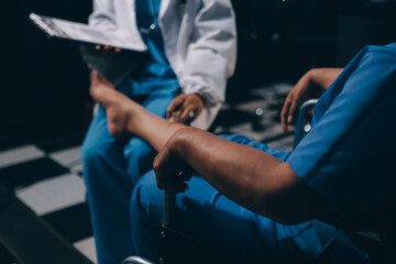 Physiotherapist nurse doing physiotherapy to rehabilitate leg of elderly female patient.