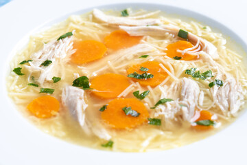 Homemade chicken soup on blue background. Close up