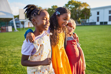 Happy female friends walking in primary school park