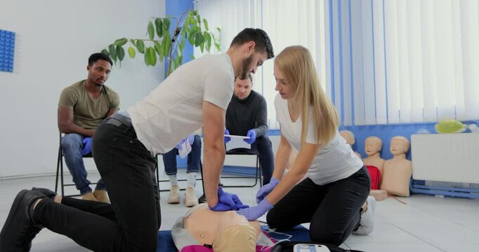 Stay away moment during the defibrillation process on a first aid group training indoors. CPR course using automated external defibrillator device - AED.