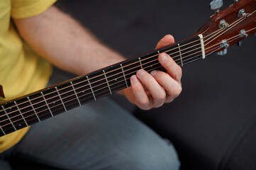 Fototapeta premium Guitarist on acoustic guitar playing melody. Close up musician instrument