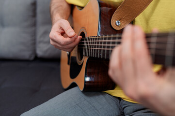 Guitarist on acoustic guitar playing melody. Close up musician instrument