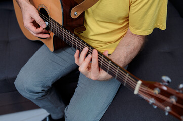Obraz premium Guitarist on acoustic guitar playing melody in studio. Close up musician instrument