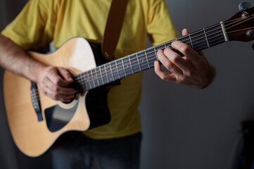 Guitarist paying a acoustic guitar in office. portrait Male musician playing music instrument