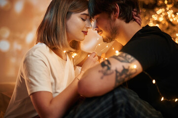 Conception of love. Beautiful young couple indoors, celebrating new year against projector