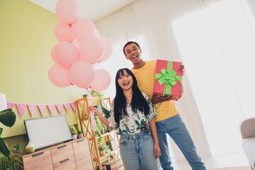 Photo of lovely positive multinational couple celebrate anniversary valentine day indoors living...