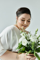 A stunning bride holds a bouquet of white flowers, exuding confidence and grace in her flowing wedding dress.