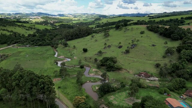 aerial view of a green landscape farm view with a river and cows in the field. Agriculture region of Minas Gerais, Brazil - Bueno Brandao .