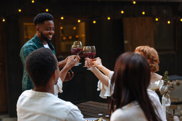 Group of friends toasting with red wine