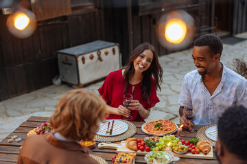 Friends enjoying red wine and a meal outdoors