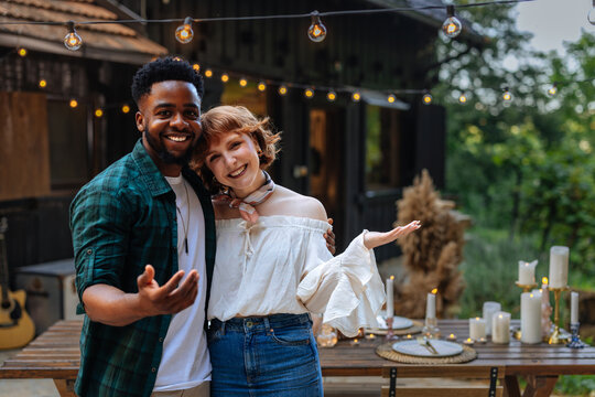 Couple posing and welcoming guests to a private dinner party