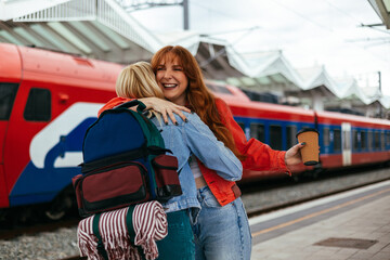 Close-up of laughing friends hugging at the station