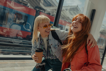 Two friends smiling at the train station